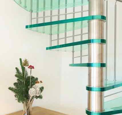 spiral staircase with glass steps and an oak sideboard