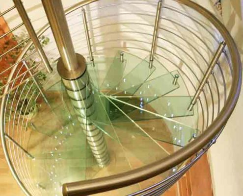 glass steps on a spiral stair with a stainless handrail