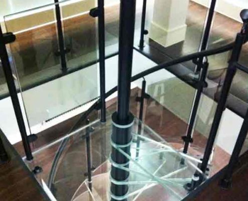 square glass platform at the top of a spiral stair with black balustrade