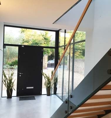 hallway with black door and black sided staircase
