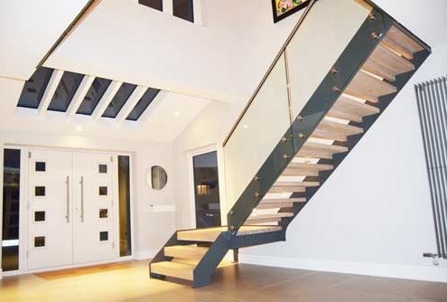 staircase with open risers and platform in large hallway