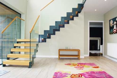 hallway with grey steel and wood staircase