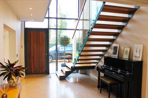 large hallway with piano and huge window with modern stair in front