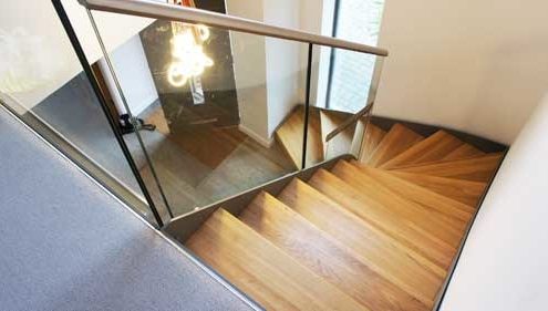 frameless glass balustrade to the side of a steel and wooden stair