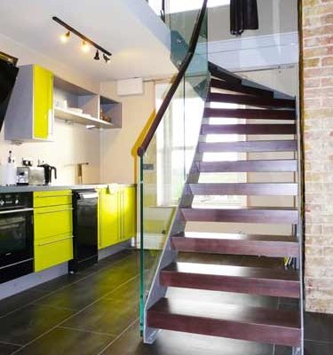 dark walnut open riser staircase with glass balustrade