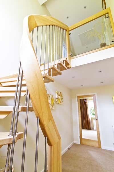 curved handrail on a light and open wooden stair