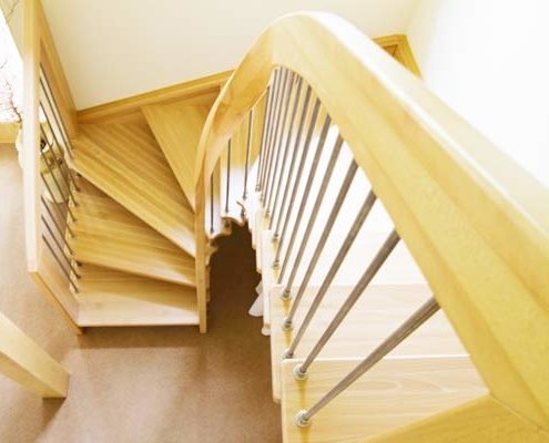 half turn wooden staircase with curving handrail