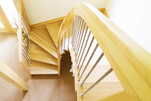 half turn wooden staircase with curving handrail