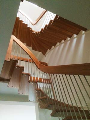 looking up at a double flight floating wooden staircase