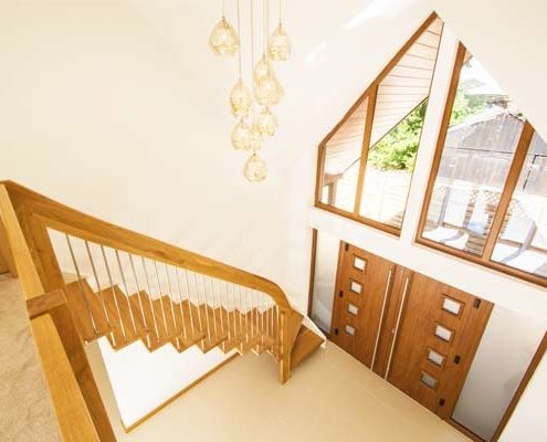 double height hallway with floating stair running up against a wall