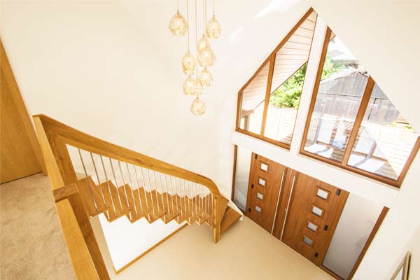 double height hallway with floating stair running up against a wall