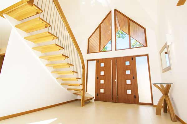 tiled floor in hallway with wooden front door and modern open staircase