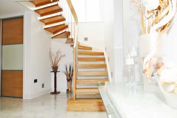 light tiled floor with oak open staircase in a half turn staircase