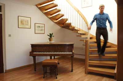 oak curved staircase above a piano