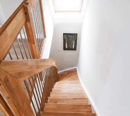 looking down a wooden staircase with landing balustrade