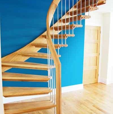 a wooden open riser staircase set Infront of a blue wall
