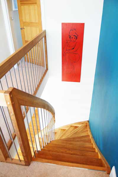 white wall with red picture and blue wall alongside an oak staircase