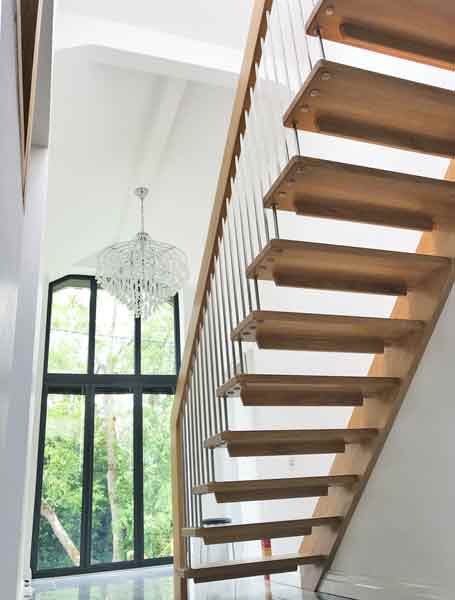 huge hallway featuring a straight flight wooden staircase with large window behind