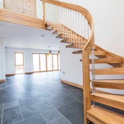 grey tiles floor with floating style oak staircase leading up