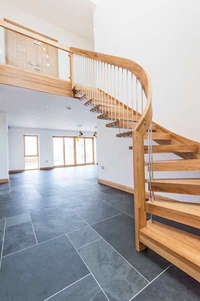 grey tiles floor with floating style oak staircase leading up