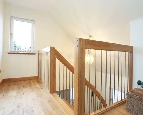 landing balustrade with oak handrail and stainless steel spindles