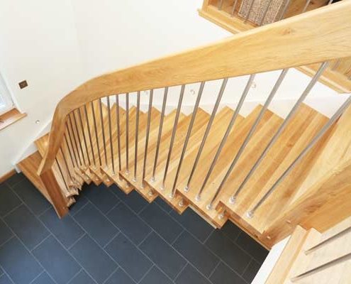 side view of an oak floating style stair with grey floor below