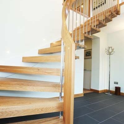 grey tiled floor in hallway with a quarter turn light oak staircase