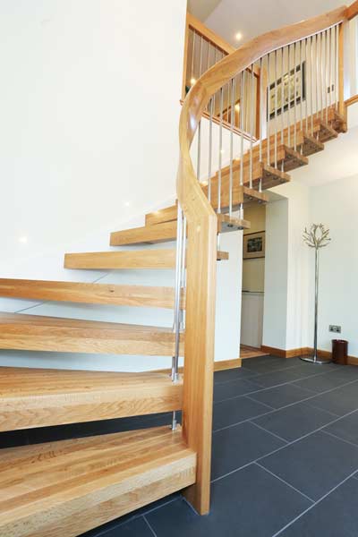 grey tiled floor in hallway with a quarter turn light oak staircase