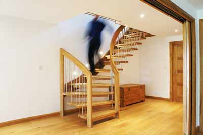 man coming down an oak staircase with open risers