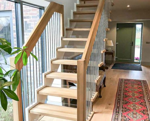 hallway with oak steps and window to one side