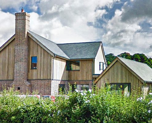Timber clad house with sky behind