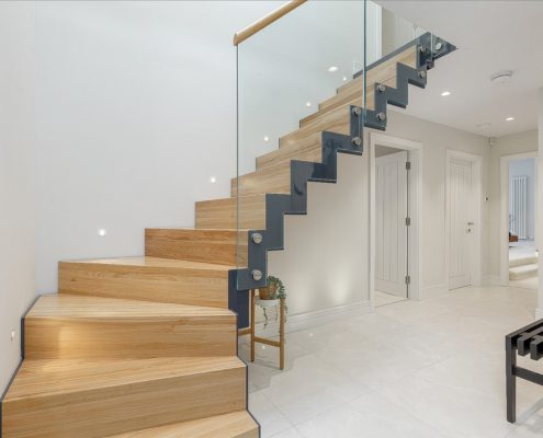 black zig zag steel stringer staircase with oak steps and glass balustrade