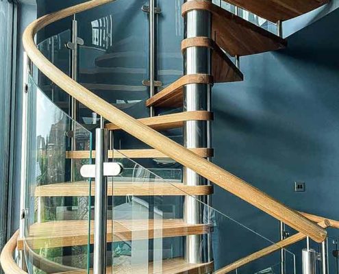 oak spiral staircase with curved glass balustrade and curved landing balustrade