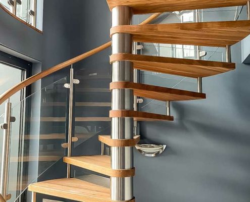 stainless and oak spiral staircase with grey wall behind