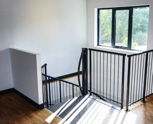 dark grey steel spindles and top platform of a spiral staircase