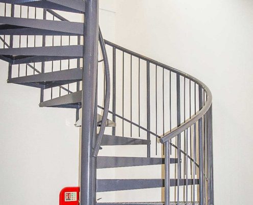 grey metal spiral staircase with steel spindles and white walls