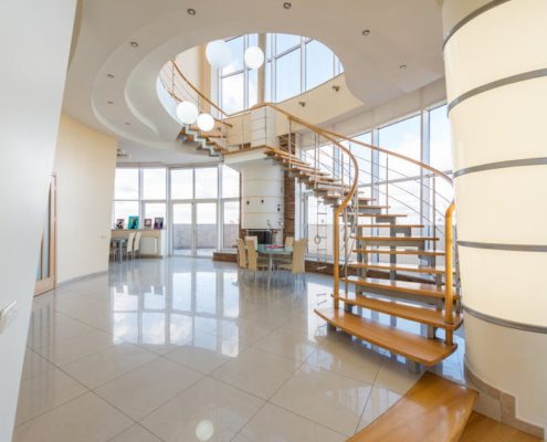 curving staircase with timber treads on a tiled floor