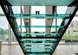 looking through the back of a glass step open riser stair to large window beyond