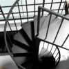 looking down on the top platform of a black steel spiral staircase