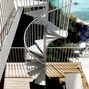 an external spiral stair running from a wooden decking to a level above with sea in background