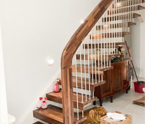 side view of a dark wooden open staircase and platform