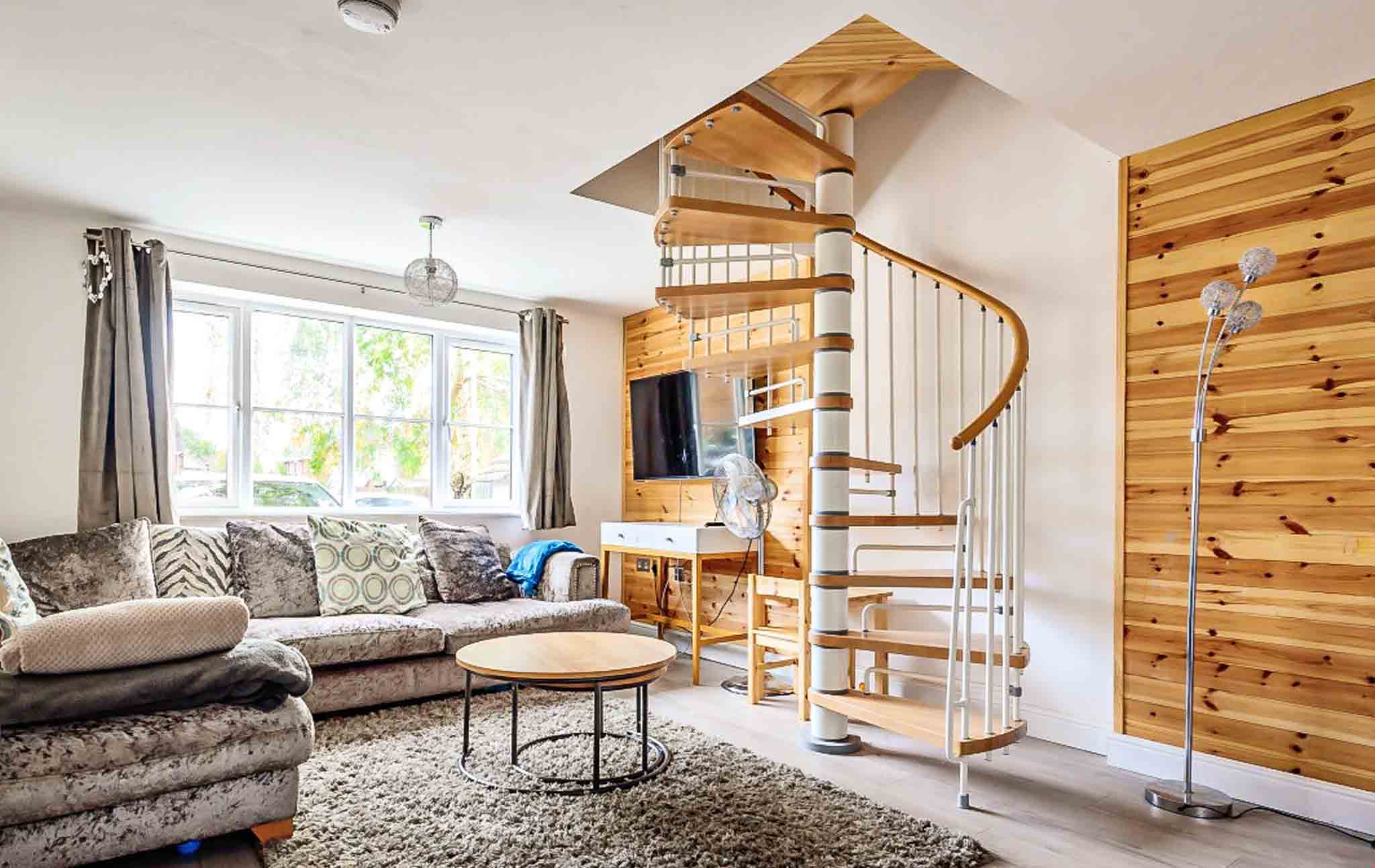 sitting room with sofas and spiral leading up