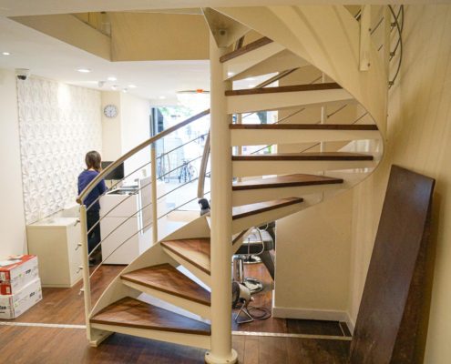 white spiral staircase in a shop with a wooden floor
