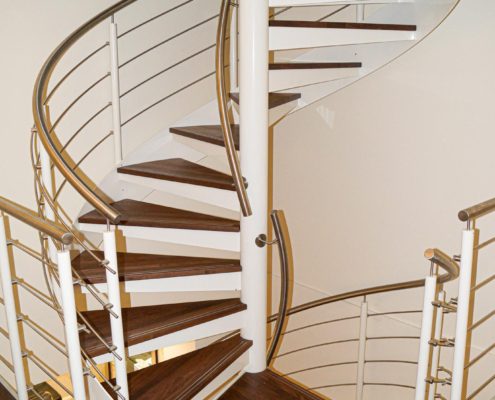 a white steel spiral stair with walnut steps