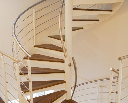 mid level view of a double flight spiral with walnut steps