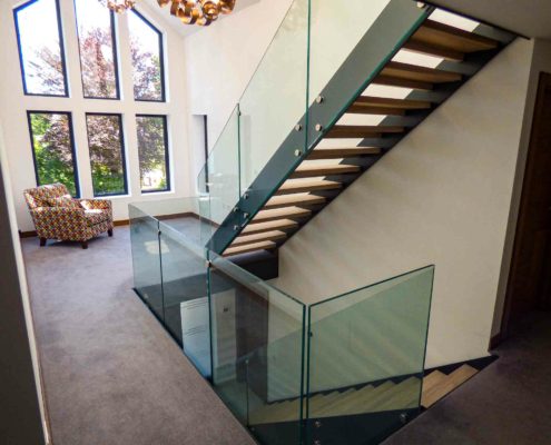 first floor look at a double flight straight stair in a modern house with grand window beyond
