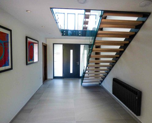 large hallway with concrete flor and modern staircase with glass