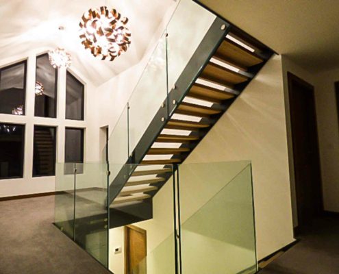 landing area with window beyond and feature glass staircase