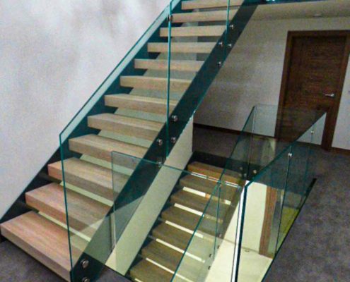 landing showing two modern glass stairs with feature wall
