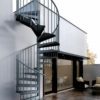 modern side of house with white render and spiral stair running to roof